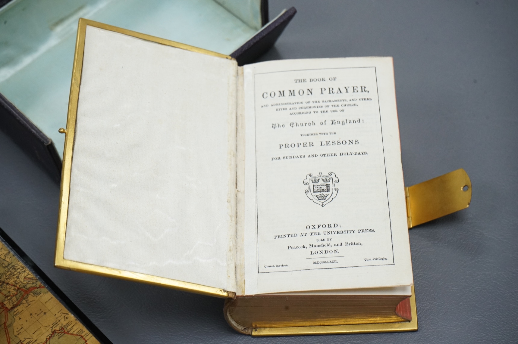 A leather boxed Common Prayer book with relief Crucifixion scene and advertising ink blotter, The Brazilian Submarine Telegraph 13cm high